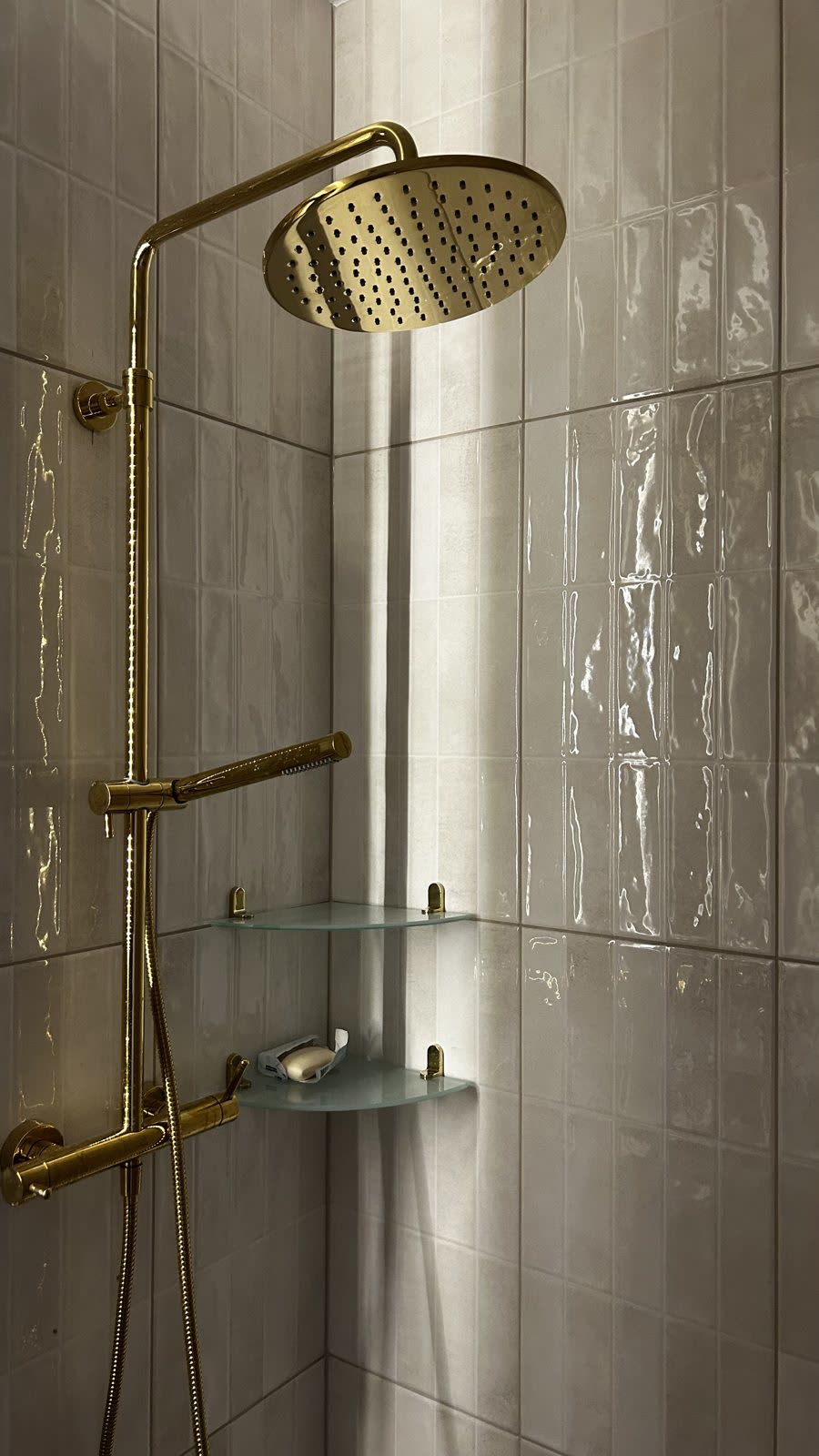 Łazienka w kamieniu i złotej armaturze, realizacja WIZJA Interior Design Studio
