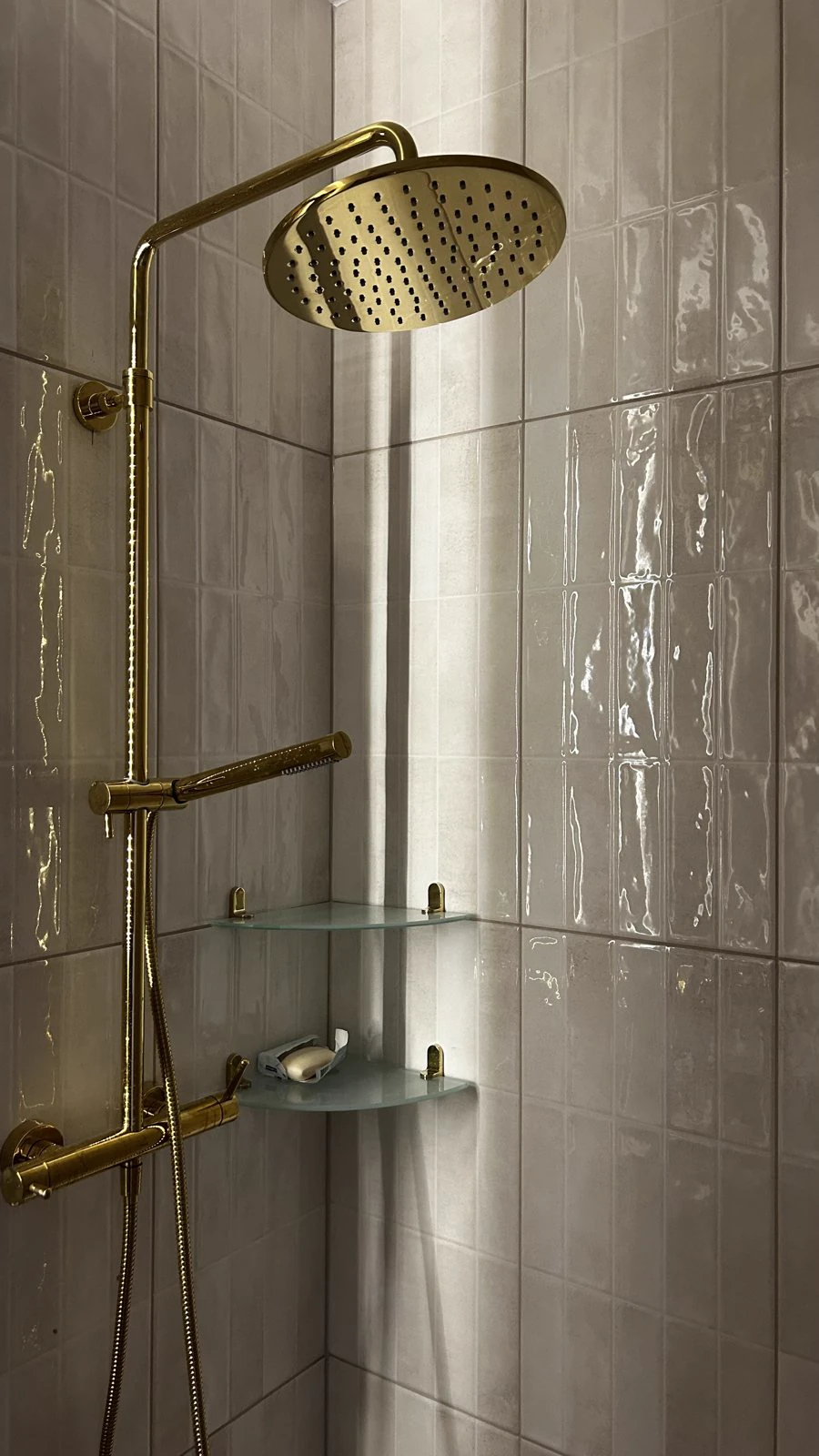Łazienka w kamieniu i złotej armaturze, realizacja WIZJA Interior Design Studio