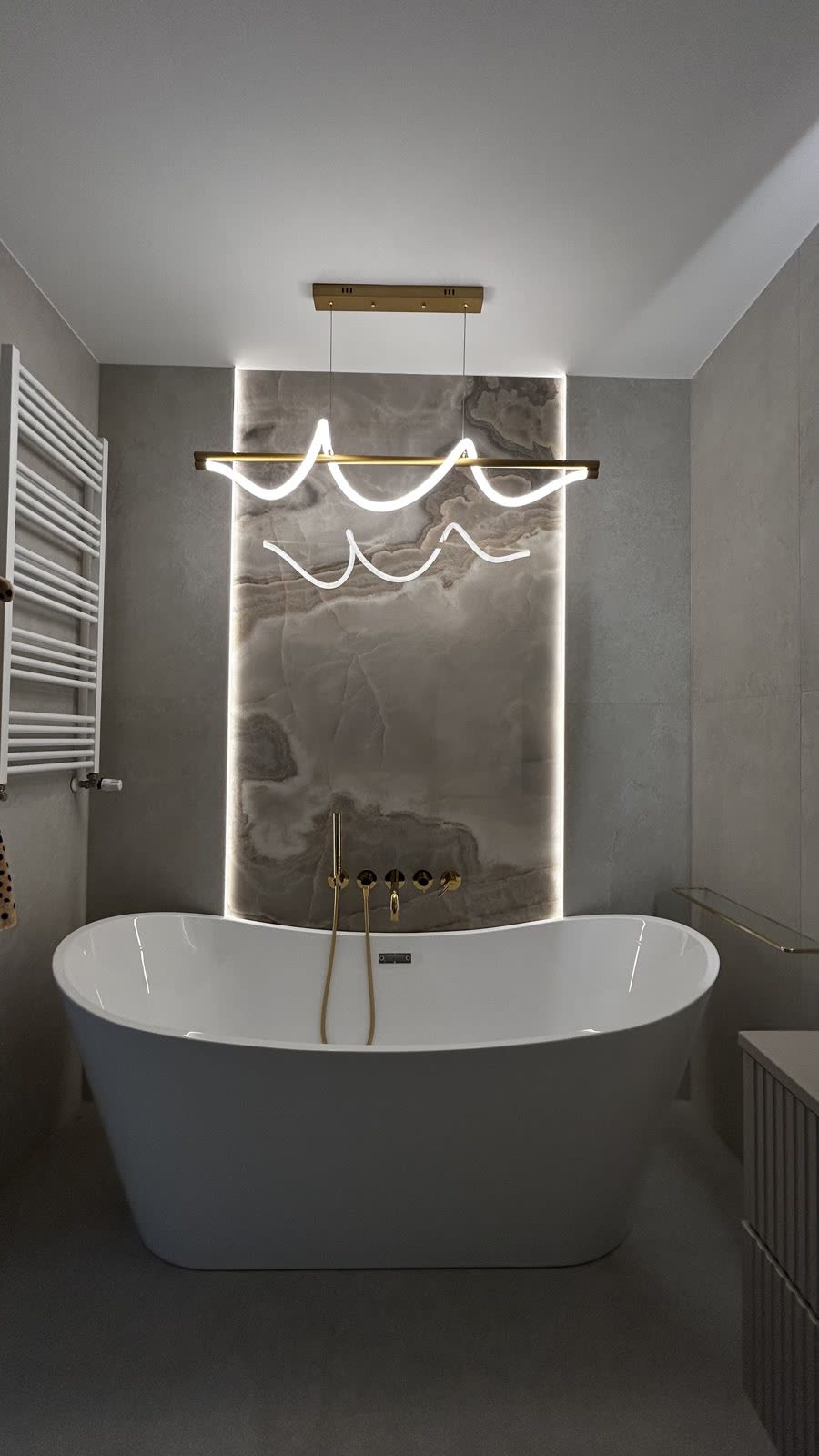 Łazienka z podświetlaną ścianą z onyksu, realizacja WIZJA Interior Design Studio